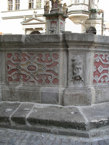 Decorative surrounds of a well in town centre.