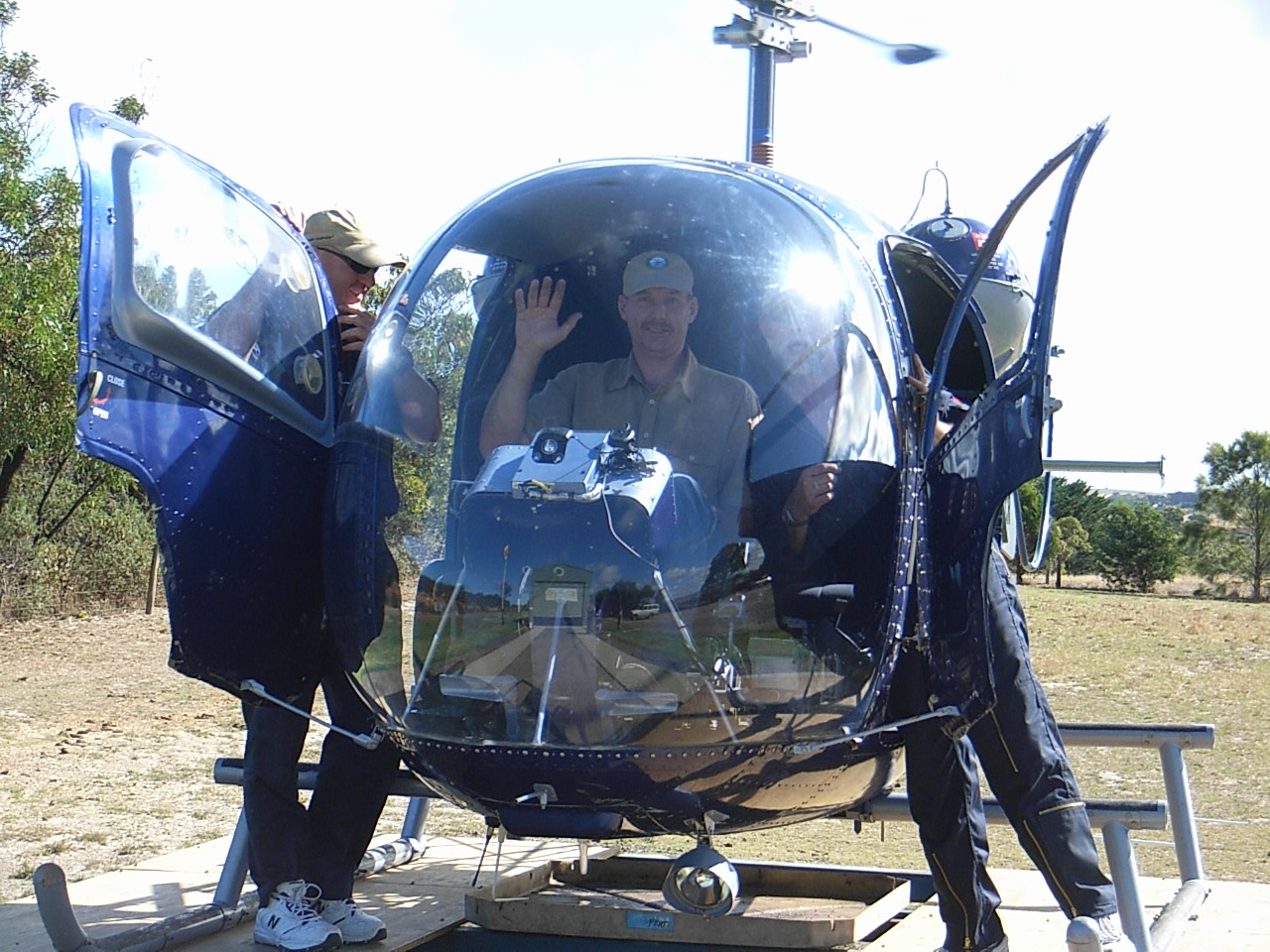 My husband is a helicopter pilot. He mostly does crop spraying and survey work. Today however, he gets to be the family's tourist pilot. The guys that own the helicopter are friends of ours. They are Steve and Wayne. They are standing each side of the machine. All are pulling goober faces for the camera.