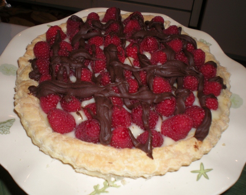 Labor Day dessert was supposed to be raspberry Napoleons, but the pastry burned, so I had to start from scratch.  I cobbled together the leftover bits and pieces of pastry to form the crust of this tart.  I melted chocolate with a raspberry liqueuer then spread half of it over the crust, topped that with a cheesecake custard and raspberries, then drizzled the rest of the chocolate over the top.  It actually tasted quite good, but I'm sure it would be better with a "proper" crust!