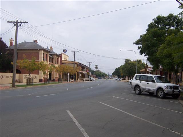 A typical main street in an outback country town on a Saturday afternoon. A few cars are parked where a shop is open but otherwise it's very quiet.