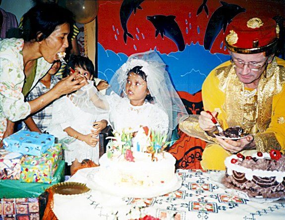 Me to the right in hired, early-19th-century real Sumatran Sultan's gear. The little girl - the youngest of my 'Sumatran surrogate family' in party fancy dress. We each have a birthday cake; our birthdays co-incided; I was 59; she was 4. There were about 40 guests from the village. The left-side lady is the little girl's mum and my friend's sister. I personally financed this party and it was good value for money!