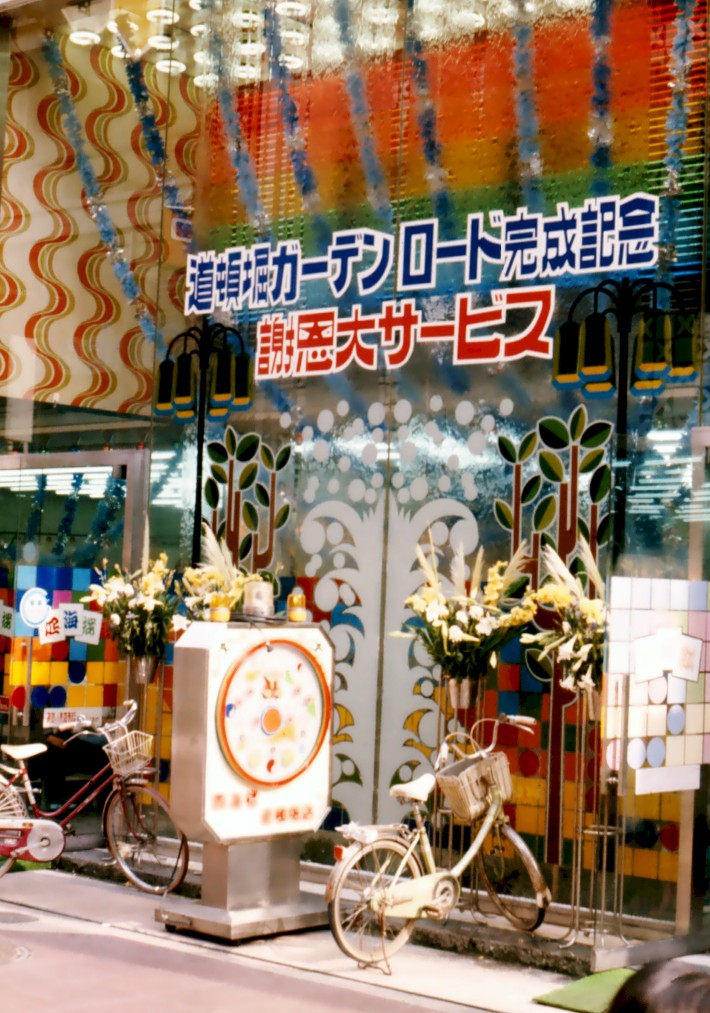 The entrance to a pachinko (pinball) parlour; Umeda, Osaka, Japan; 1975.   Pachinko appears to be the Japanese national sport. Usually packed with punters, the parlours advertise themselves at distance with the swishing sound of balls circulating within the machines.