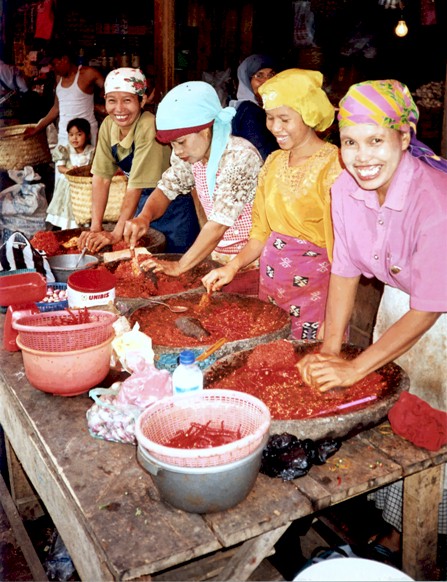 West Sumatran beauties grinding chillis on a market stall in Payakumbuh. "We like foreign photographers taking our picture"