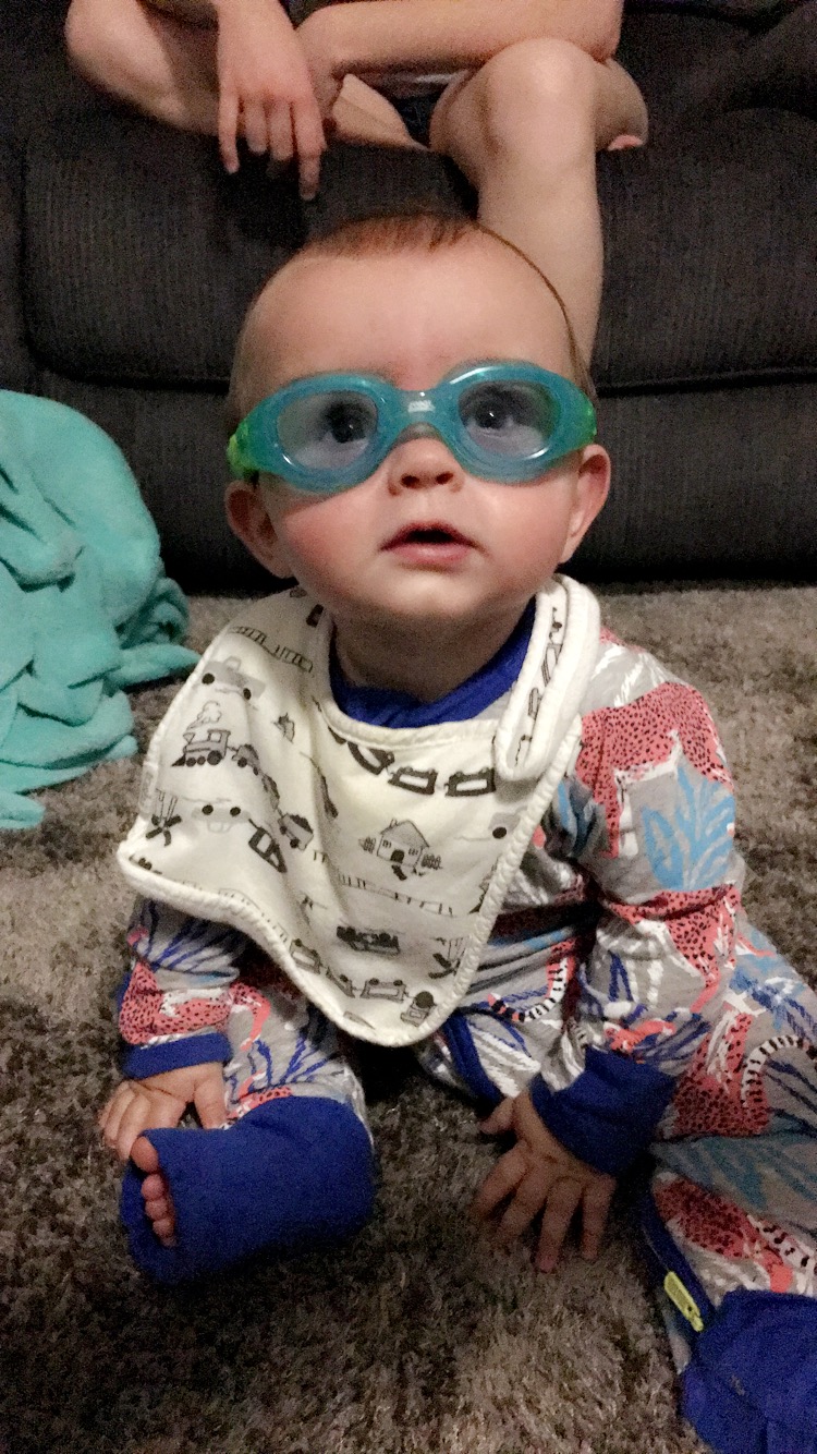 Trying on his swimming goggles. He doesn't wear them in the pool as they prefer them to learn without them.