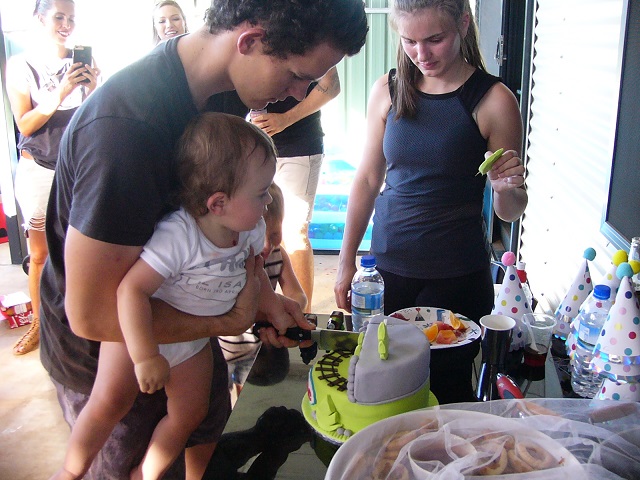 Cutting his cake with his Dad and Mum