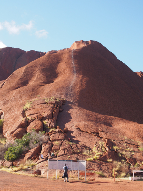 Climbers on Uluru.  3 or 4 people each year die climbing the rock.  A notice at the bottom asks people not to climb.  This will be forbidden soon as the constant foot traffic has made it too slippery and dangerous to climb.