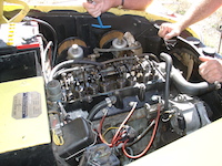 The engine of the 1950's Austin Atlantic being worked on by some 'bush mechanics'.