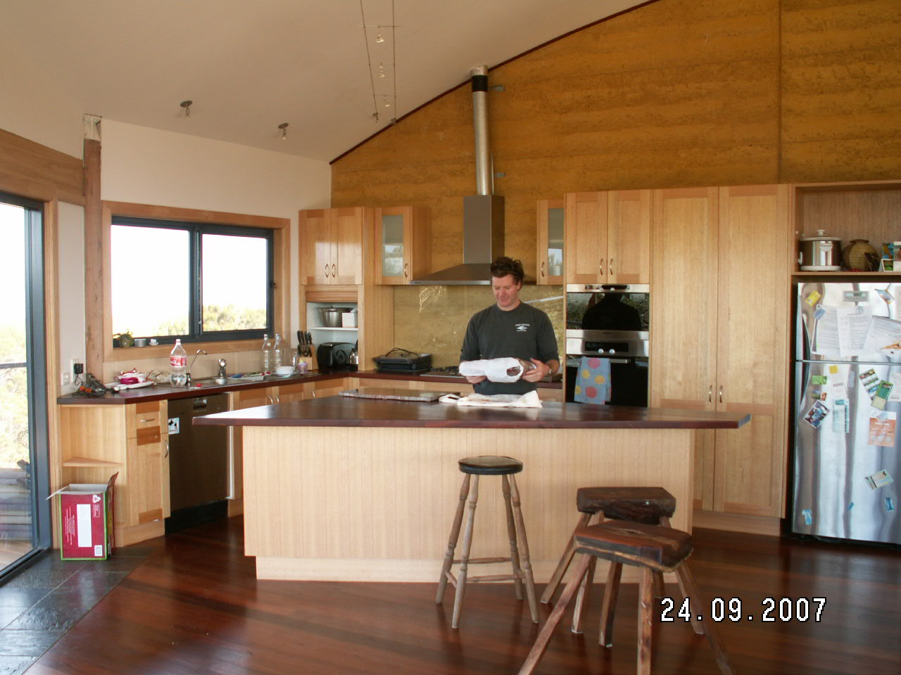 You can see the curve on the rammed earth wall that supports the roof and divides the house into two. This half is open space. Behind the wall are the bedrooms and bathrrom.