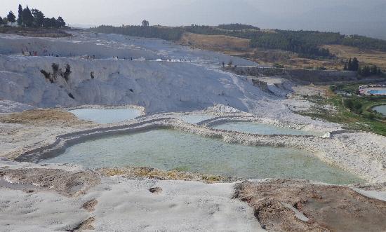 The city contains hot springs and travertines, terraces of carbonate minerals left by the flowing water