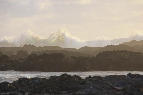 The waves dancing towards the rocks in the late afternoon light.