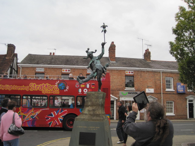 commonly known as the fool, taking a picture of some statue with his iPad.